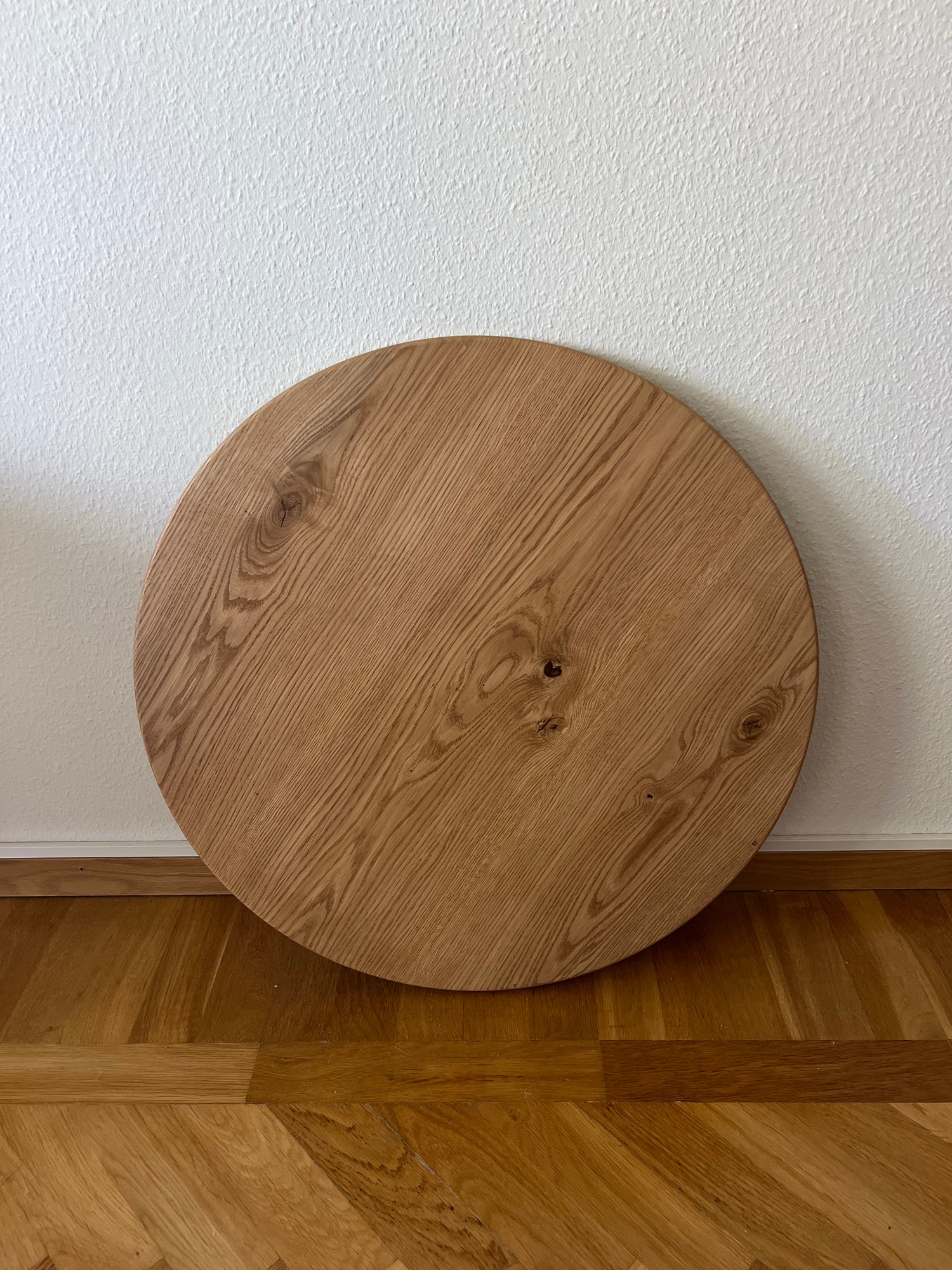 Närbild på en rund bordsskiva i massiv ek, med tydlig träådring och sin hårdvaxoljade finish.