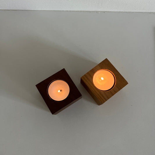 Ljushållare i två träslag, valnöt och ek, stående bredvid varandra och visar kontrasten mellan mörk och ljus träton.