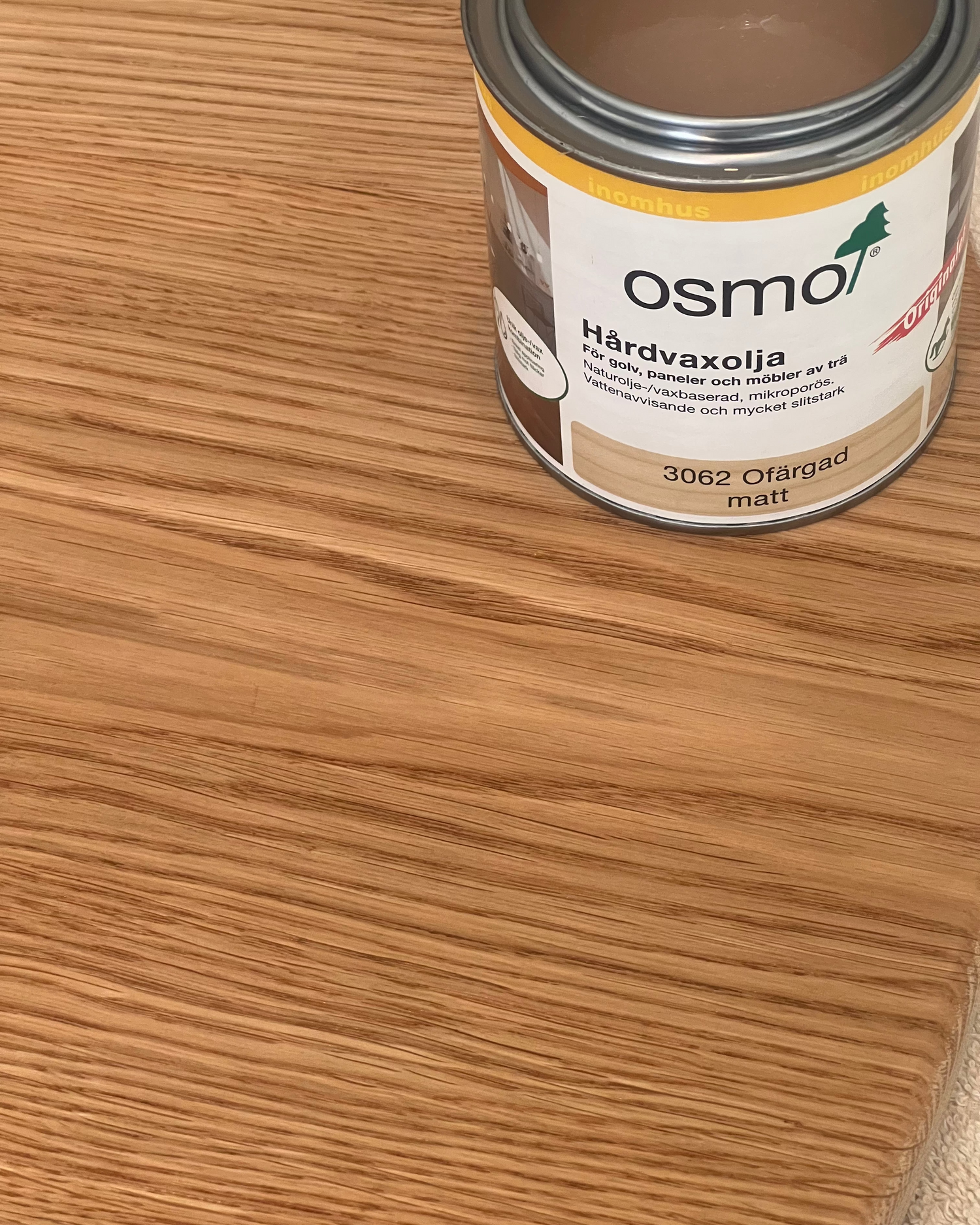 Burk med Osmo träolja, används för ytbehandling av trä för att skydda och framhäva träets naturliga ådring.