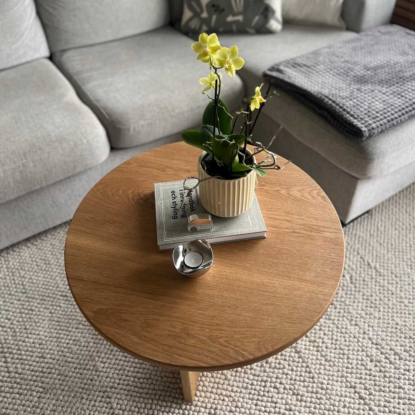 Närbild på bordsskivan av det runda bordet Helge i massiv ek, med tydlig träådring och naturlig finish.